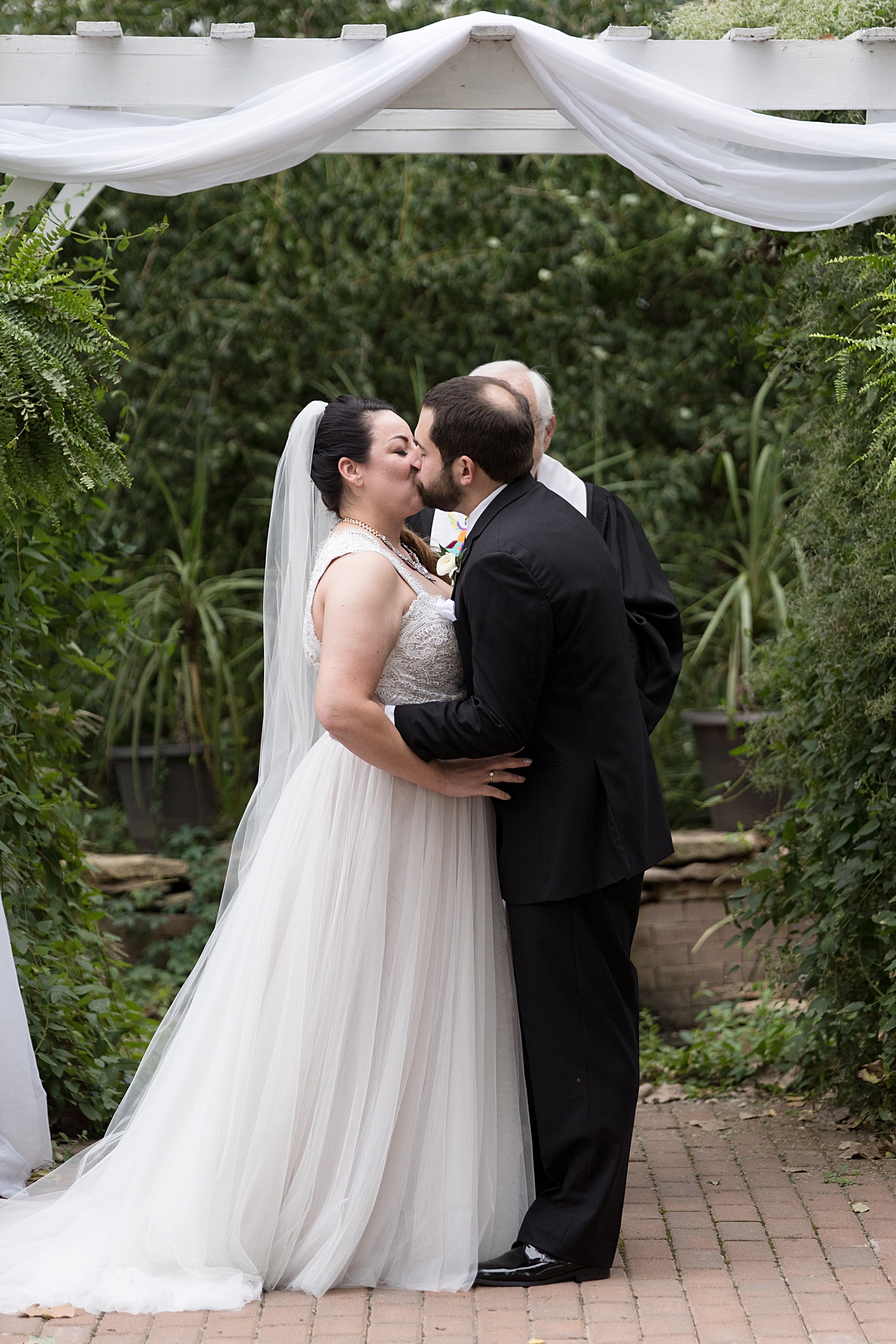 First kiss at garden wedding ceremony. VVI Wedding - Victoria Veranda Country Inn Wedding Photos- Lawrence, KS-Wedding-Photographer-Emily-Lynn-Photography